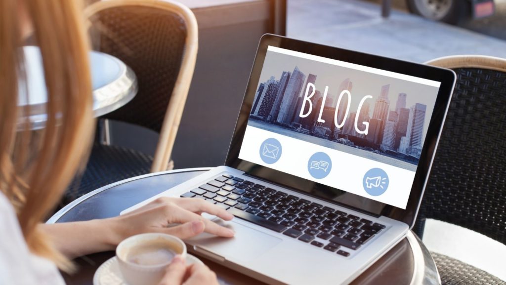 A person using a laptop to write a blog, symbolizing the creation of valuable content for quality link building